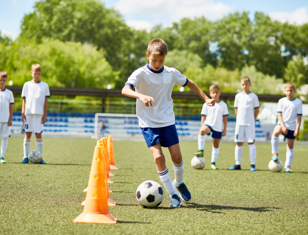 Mehrere Jungen lieferten sich auf einer grünen Wiese ein lebhaftes Fußballspiel, bei dem Teamwork und Begeisterung im Vordergrund standen.